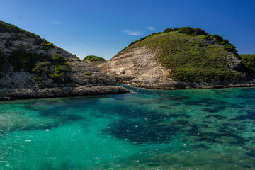 Fototapeta premium Natural landscape with mountain and blue sky, turquoise waters, eaux turquoises, lake, lac, paysage naturel avec montagnes et ciel bleu, Bonifacio, Corsica, Corse, France