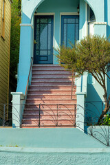 Stone red steps with blue timber framed hand rails and wooden house or home with blue cement wall...