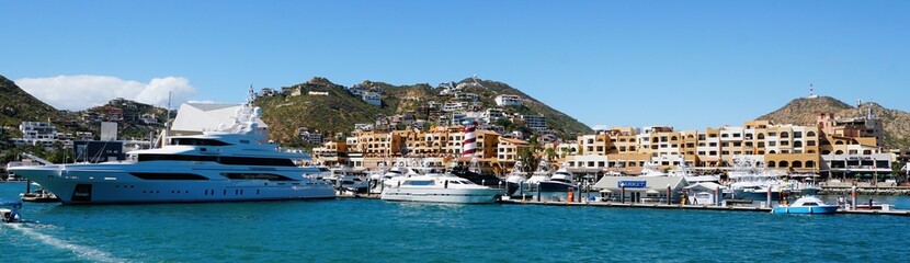Fototapeta premium The panoramic view of the city with luxury boats, waterfront homes and resort hotels by the bay near Cabo San Lucas, Mexico 
