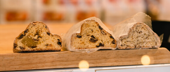 Close-up of Stollen, traditional German sweet fruit bread for Christmas with raisins and marzipan coated with powdered sugar also called Weihnachtsstollen or Christstollen, landscape header image - 550158404