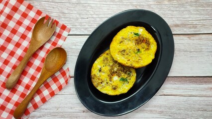 Indonesian pancake Serabi or surabi is a traditional market snack originating from Indonesia served on a black plate with a wood texture background