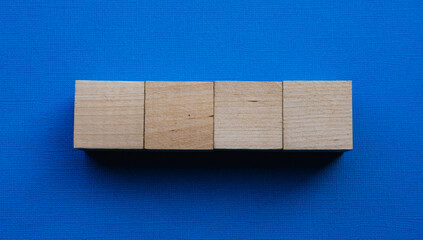 Four wooden cubes on a blue background, mocap