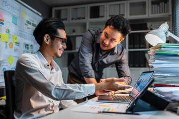 Asian handsome two businessman using laptop computer working in office. 