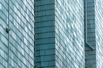 Obraz premium Row of exterior facade with gaps between them on wooden or timber slatted pannels on walls with pipes in midday shade