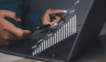 Stock market graph with man working on laptop stock trading.