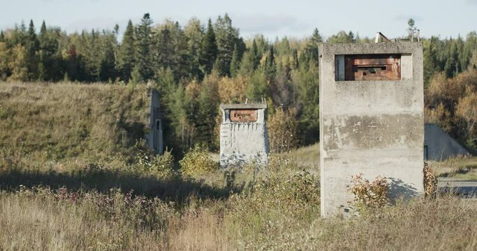 Two machinegun pill boxes stand guard at a special military security area with bunkers visible in the background.