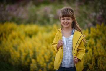 Cute walking beautiful little girl in yellow jacket