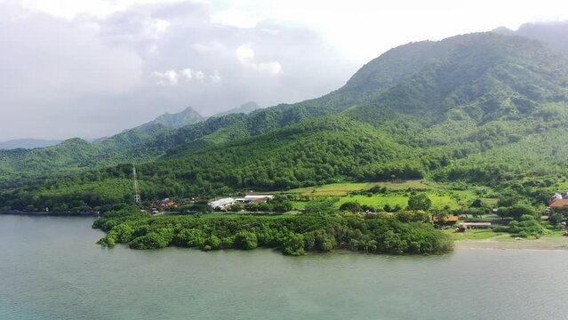 Aerial view of Java's north coast, Situbondo, East Java, Indonesia against the mountains. Travel footage
