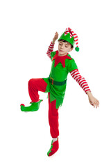 Full length portrait of an adorable 10 year old boy dressed in a Christmas elf costume dancing, isolated on a white background - 550181226