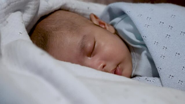 Adorable Sleeping Two Month Old Indian Boy Wrapped in Blue Blanket. Close Up