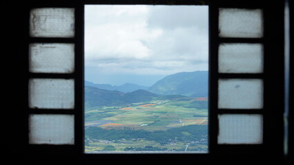 The beautiful mountains and yellow harvesting rice field view looking out of the window