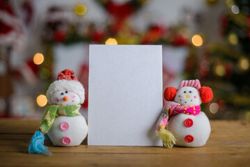 Blank Christmas card next to ornament on wooden table, Christmas background blurred. Christmas card mockup.
