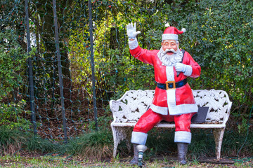 Life-Sized Waving Santa Claus Figure and White Bench in New Orleans, Louisiana, USA