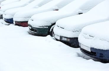 cars standing on the snowy parking lot in winter day after heavy snowfall