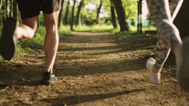 Back view of two athletic people running in the countryside. Healthy lifestyle concept.