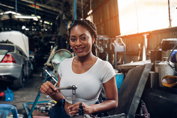 Fototapeta na wymiar Portrait of woman auto mechanic working at car repair shop with looking at camera. 