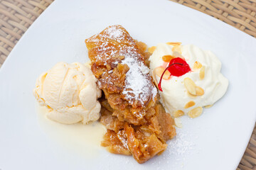 Apple strudel pie on powdered sugar, vanilla ice cream scoop and whipped cream with almonds. Sweet dessert, Austrian food concepts