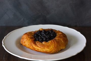Blueberry baked pastry pie on white plate. Sweet dessert from bakery