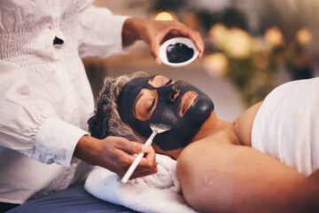 Senior woman, charcoal face mask and at spa to relax, clear and smooth skin. Luxury, mature female and black paste for organic facial detox, natural beauty and wellness for peace, calm and skincare.