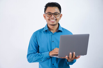 smiling or happy asian businessman with glasses holding laptop wearing blue shirt isolated on white background