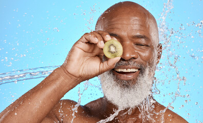 Fototapeta na wymiar Skincare, kiwi and senior man in studio for beauty, water splash and wellness on blue background mockup. Beauty splash, fruit and water with elderly man cleaning, happy and relax with nature product