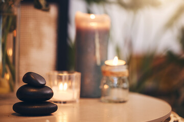 Stone, candle and spa with a still life objects on a table in a wellness center for aromatherapy to relax. Background, rock and luxury with stones and candles in a health salon for stress relief - Powered by Adobe