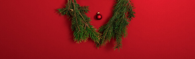 Christmas Fir Tree Branches and Ball Toy on Red Paper Background. Christmas, New Year and Winter Holiday Concept Wallpaper.