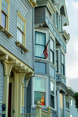 Row of house facades in the historic districts of San Francisco California in late afternoon shade with foggy background sky