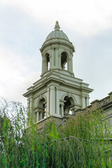 Hollow cement church steeple with hidden garden trees in a secret church courtyard on the edge of suburban city
