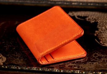 Red leather wallet on a dark background.