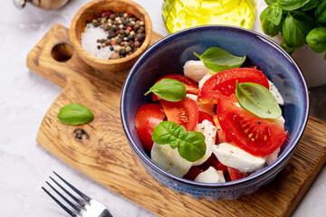 Caprese salad with ripe tomatoes, mozzarella and garden basil