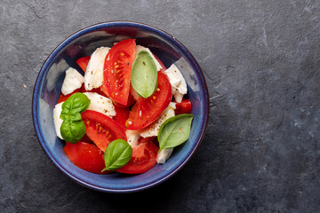Caprese salad with ripe tomatoes, mozzarella cheese and garden basil