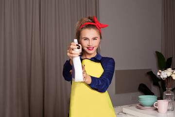 Woman in vintage style showing detergent. Pin-up woman with trendy makeup.