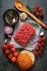 Fresh raw ingredients for preparation tasty and healthy food. Ground beef with vegetables and spices on dark background top view. Cooking background