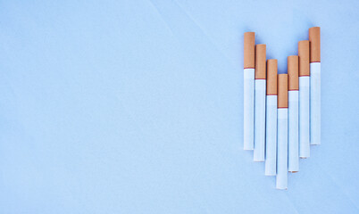 Cigarettes in a studio against a blue background mockup for cancer, toxic and addiction awareness. Cigarette, tobacco business and industry advertising for smoke, marketing and smoking market