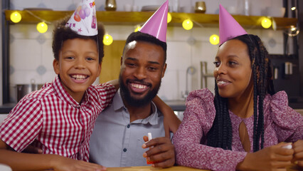 African-American family in party caps celebrating birthday online