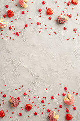 Obraz na płótnie Canvas Valentine's Day celebration concept. Top view vertical photo of heart shaped sweets candies and cookies on grey concrete texture background with copyspace