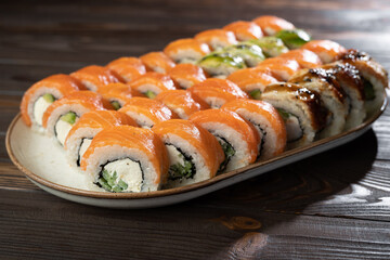 Philadelphia roll sushi with salmon, avocado, cream cheese on wooden table. Sushi menu. Japanese food