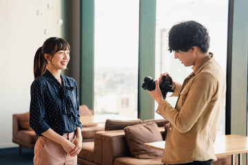 Fototapeta premium 女性のポートレート写真を撮影する男性フォトグラファー