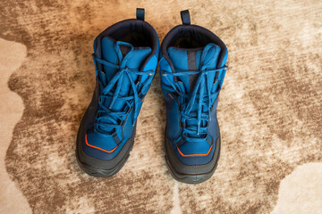 blue outdoor boots on the carpet.