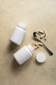 White pill bottles on warm background. Health care food supplements, vitamins and medicaments