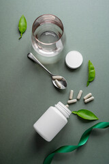 White pill bottles on green background. Health care food supplements, vitamins and medicaments