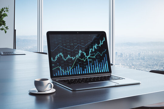 Close up of desktop with laptop and glowing business chart hologram and index on screen. Blurry office background with city view and coffee cup. Finance, trade and invest concept. 3D Rendering.