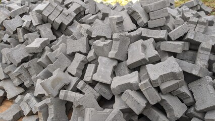 Heap of street cement paver blocks putting on the ground. Cement bricks for pavement roads or building yards. Pattern of gray sidewalk tiles in India