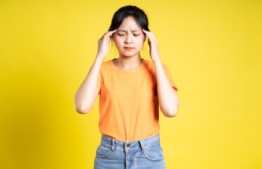 Asian girl posing on yellow background