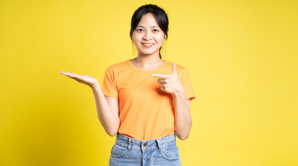 Asian girl posing on yellow background