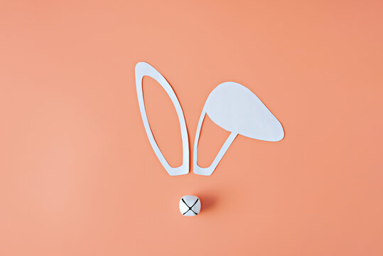 Minimalistic New year composition. Bunny face made from paper ears, Christmas bell.