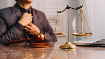 Justice and law concept.Male judge in a courtroom with the gavel, working with, computer and...