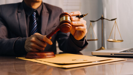 Justice and law concept.Male judge in a courtroom with the gavel, working with, computer and...