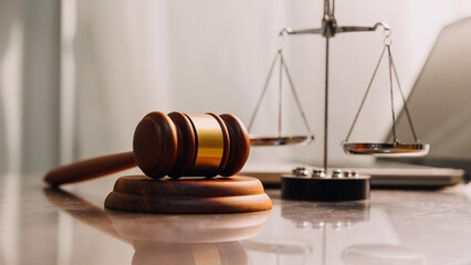 Justice and law concept.Male judge in a courtroom with the gavel, working with, computer and...